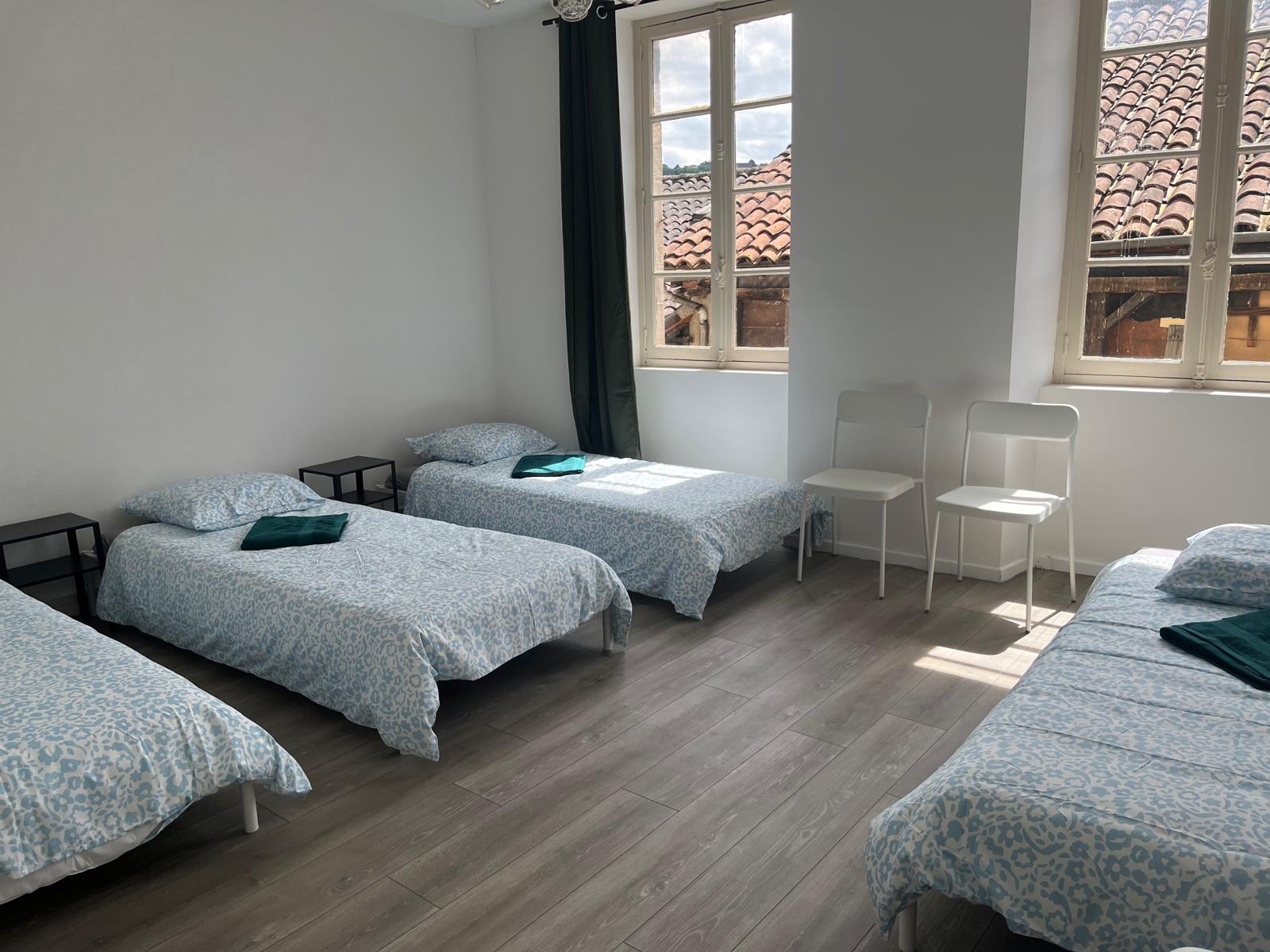 Chambre avec plusieurs lits à l'Accueil Saint-Joseph Figeac